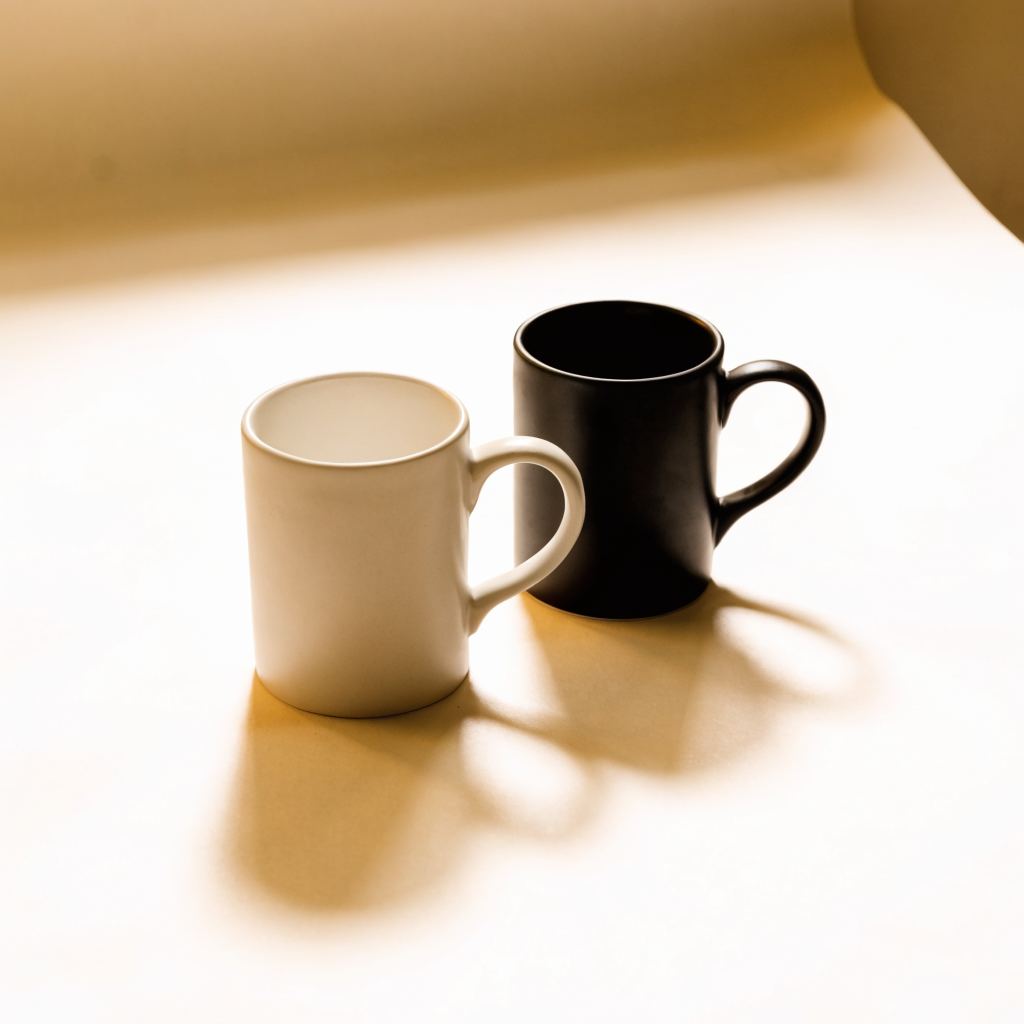 Tazas de cerámica blanca y negra sobre fondo claro